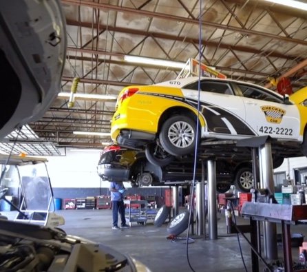 White and Yellow Mears taxi being serviced in the mears inspection facility